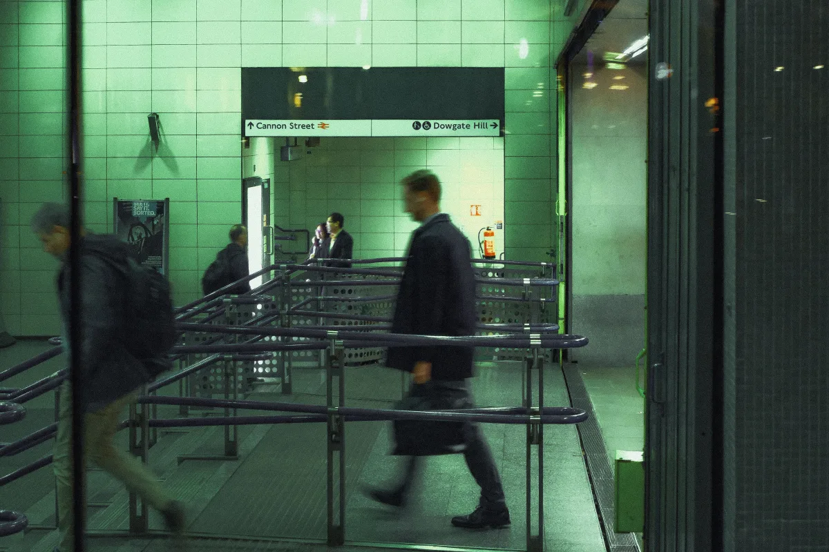 Blurred commuters passing through the barriers at Cannon Street Underground station